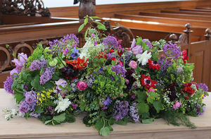 een rouwboeket van schoon geteelde bloemen, van ongeveer 90 cm groot